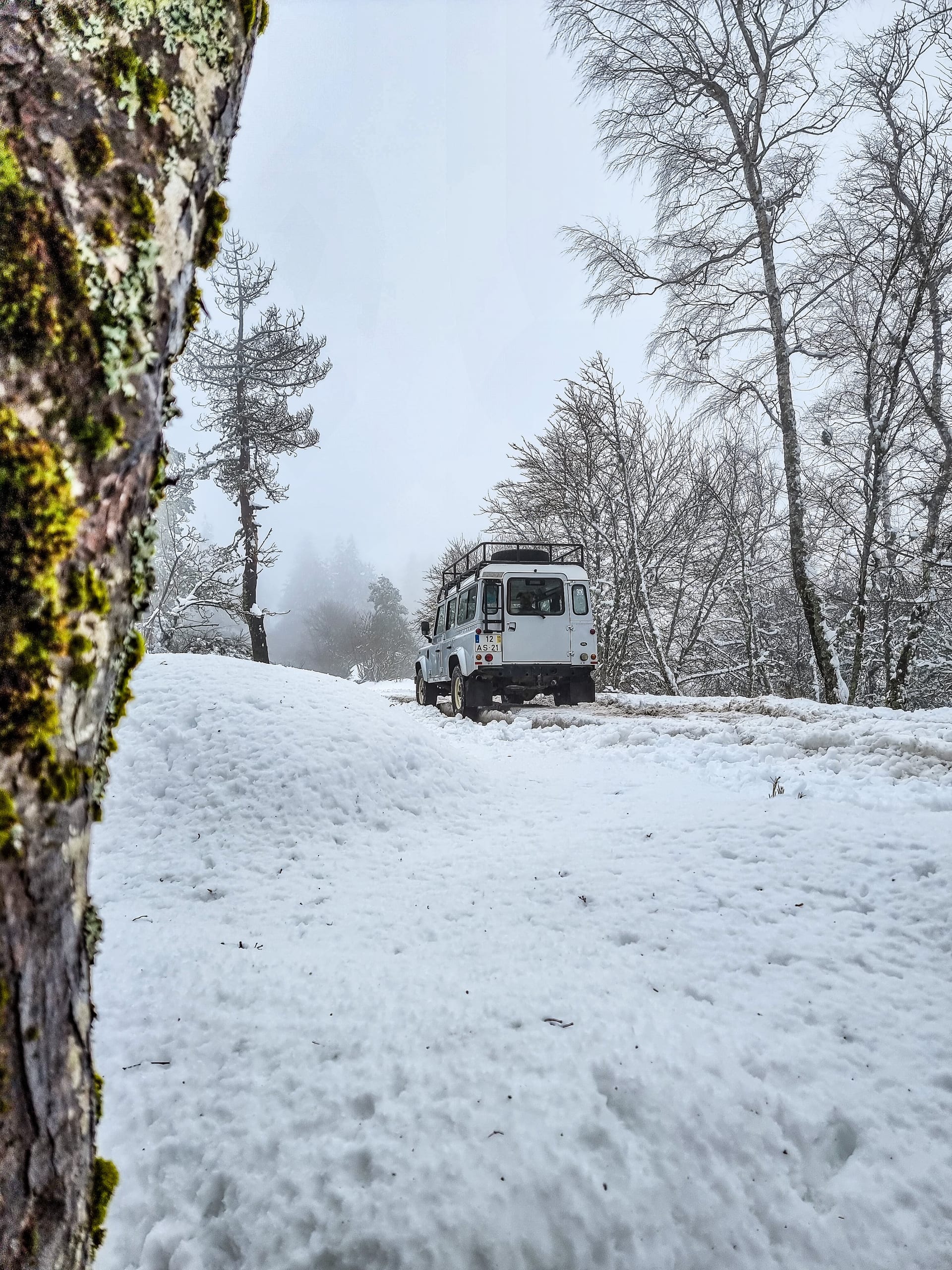 Veículo 4x4 a avançar por uma estrada coberta de neve